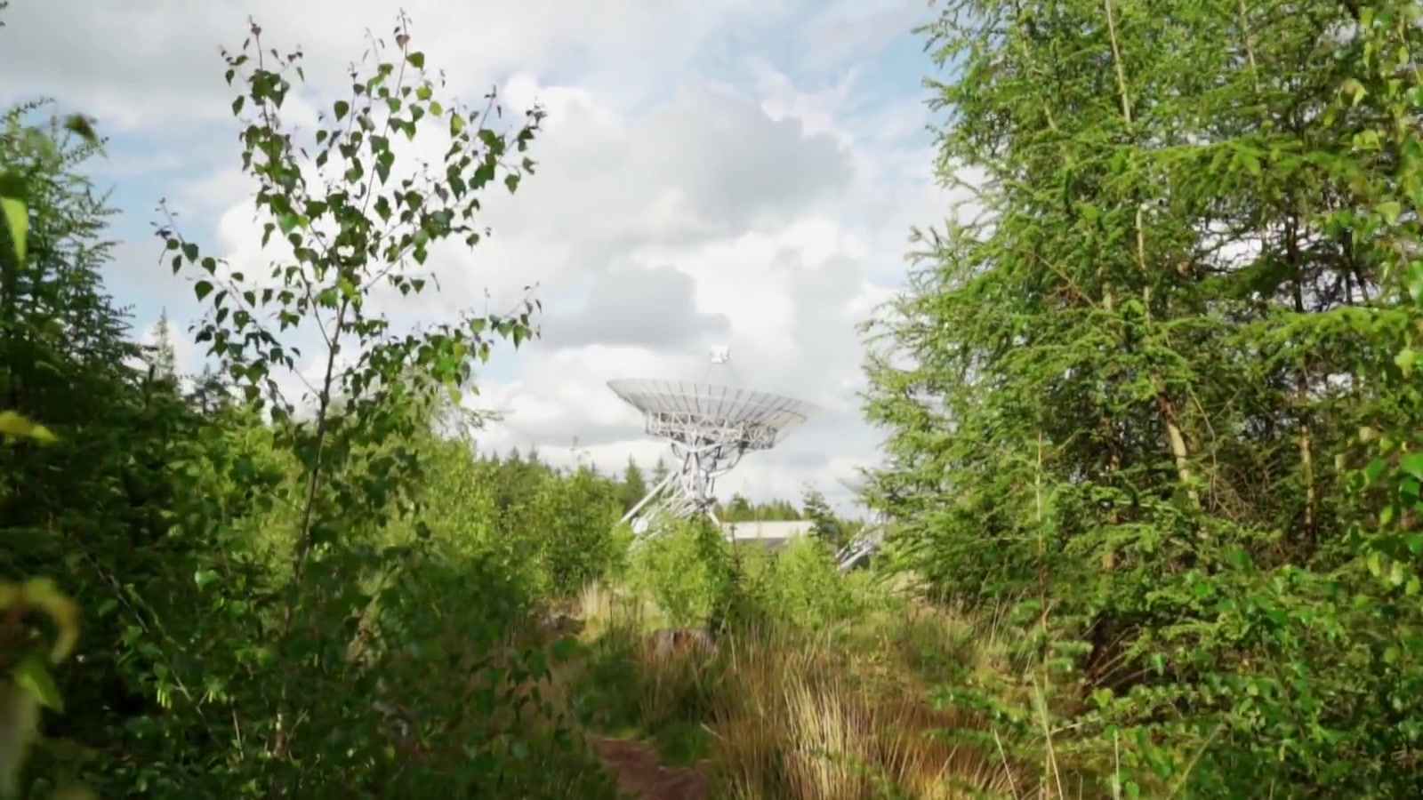 A civilian satellite dish moves against the sky.