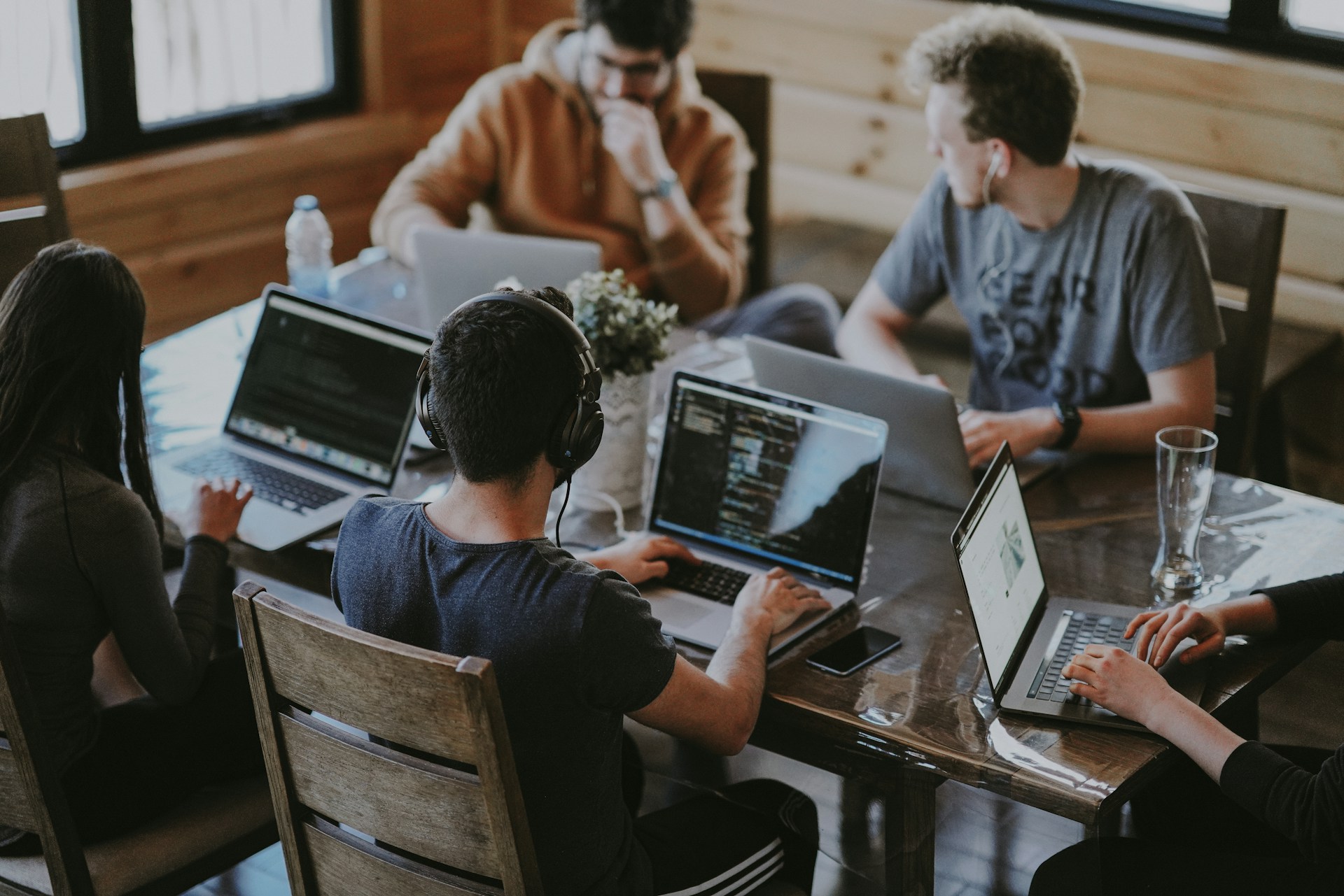 Colleagues work together around laptops in an office.