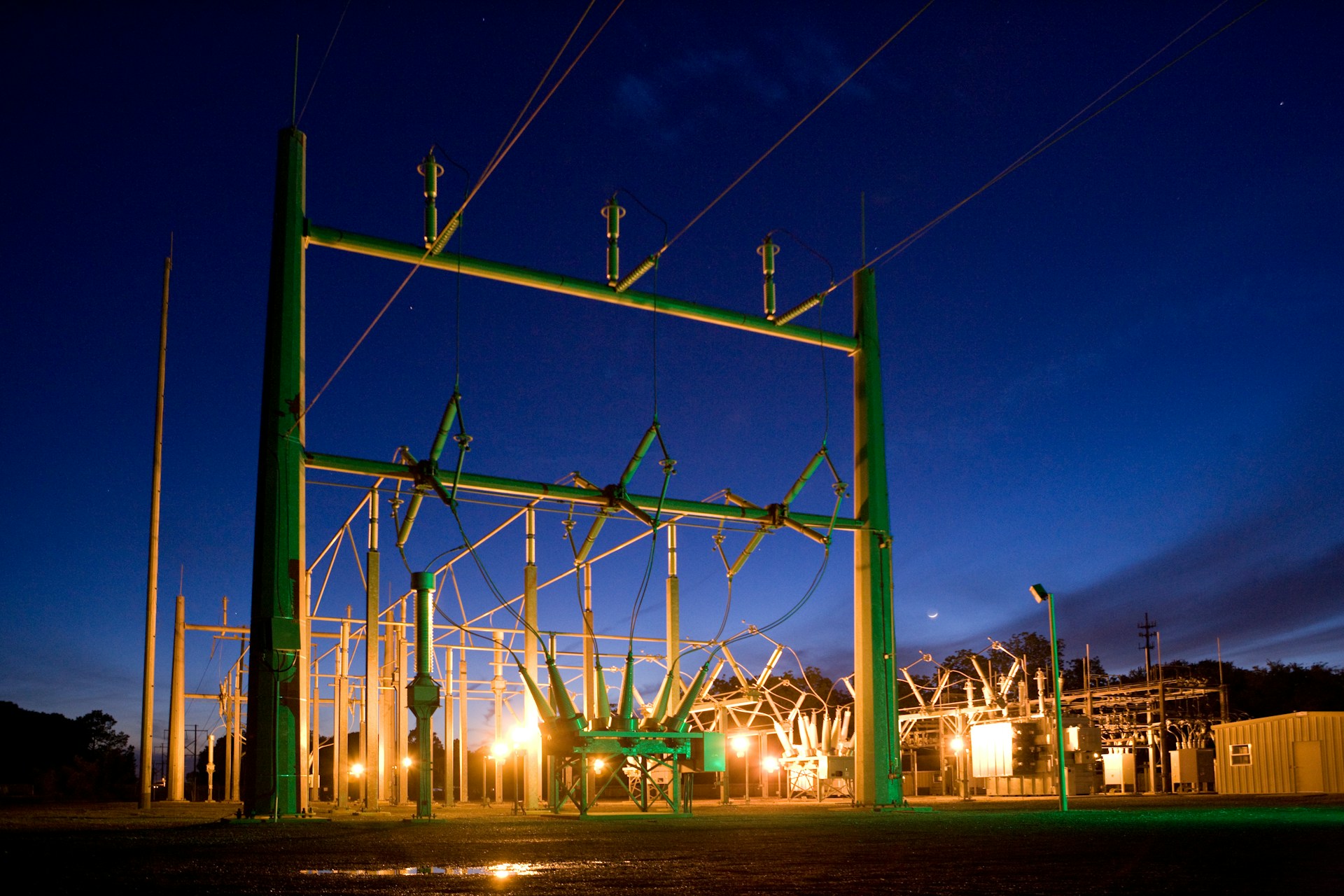 Electrical power infrastructure illuminated at night.